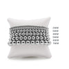 A display of sterling silver stretch bracelets in various sizes, ranging from 2mm to 8mm, presented on a white cushion.