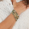 Close-up of a wrist wearing multiple bracelets on a white textured background
