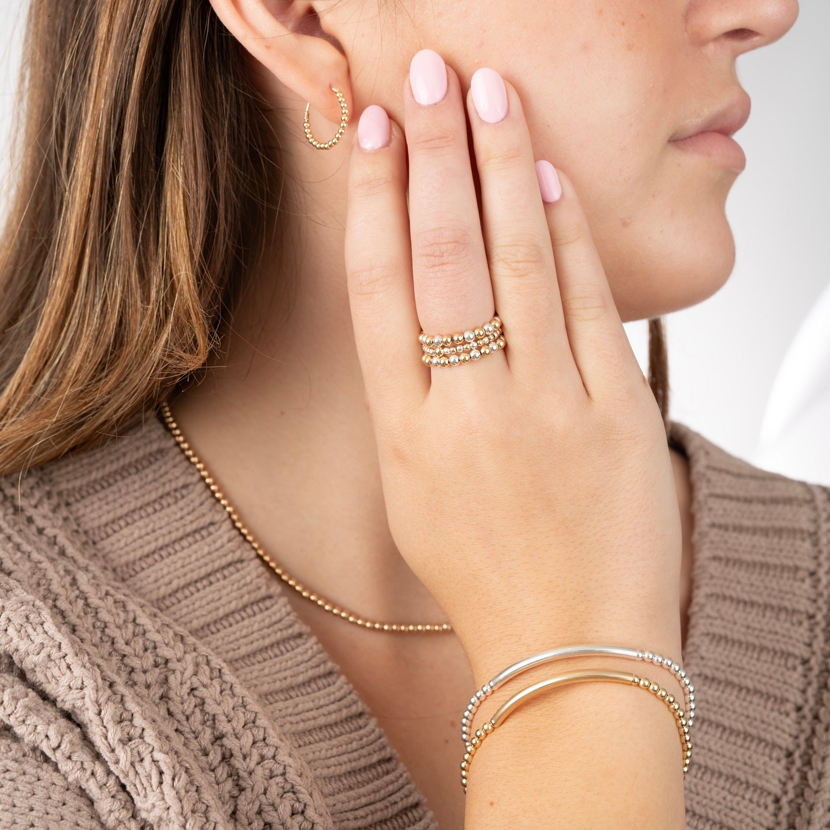 hand of model showing several rings and bracelets on wrist