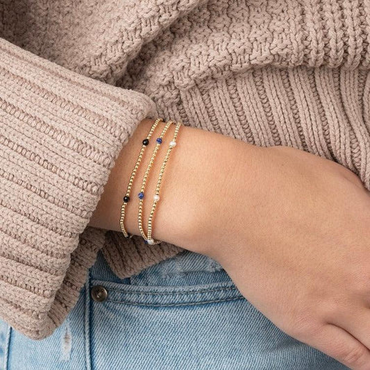 Model wearing gold filled beaded gemstone bracelets with gemstones