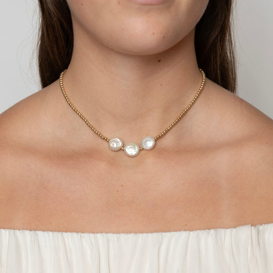 Model wearing a gold-filled beaded necklace with 3 coin pearls