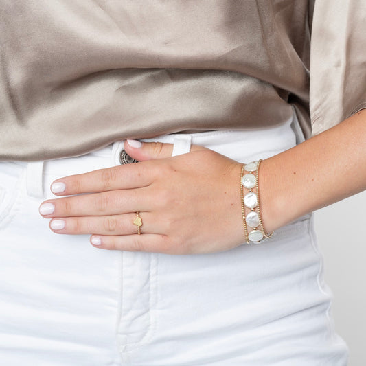 Model wearing coin pearl and gold beaded bracelets
