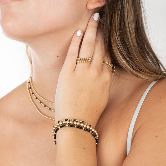 Model wearing gold-filed & gemstone bracelets, rings and necklaces