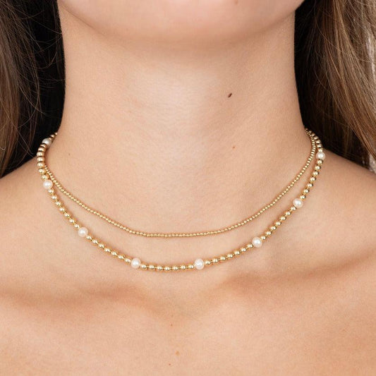 Model wearing gold filled beaded necklace and one with pearls