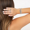 Hand and arm of model wearing various rings and bracelets
