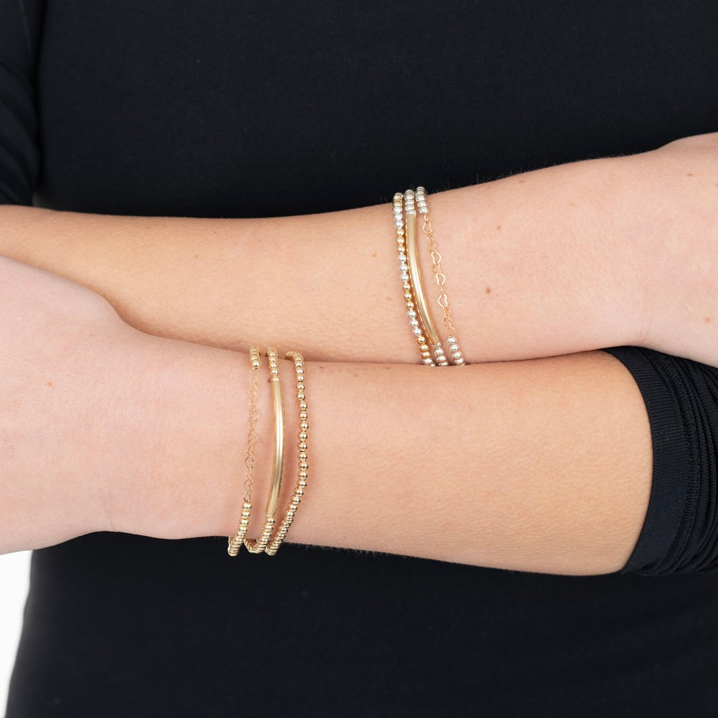 model wearing 3 bracelets on each wrist
