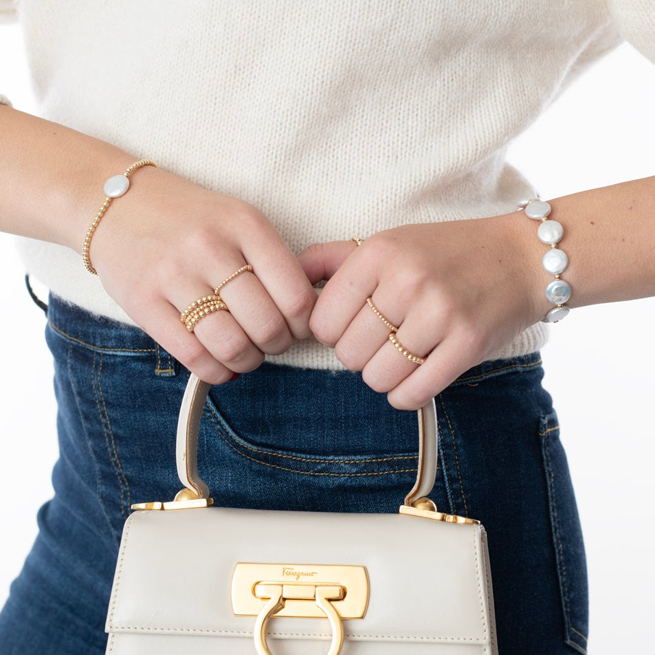 Model wearing gold-filled bracelets with pearls