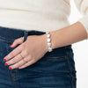 Model wearing gold-filled and pearl bracelet and rings