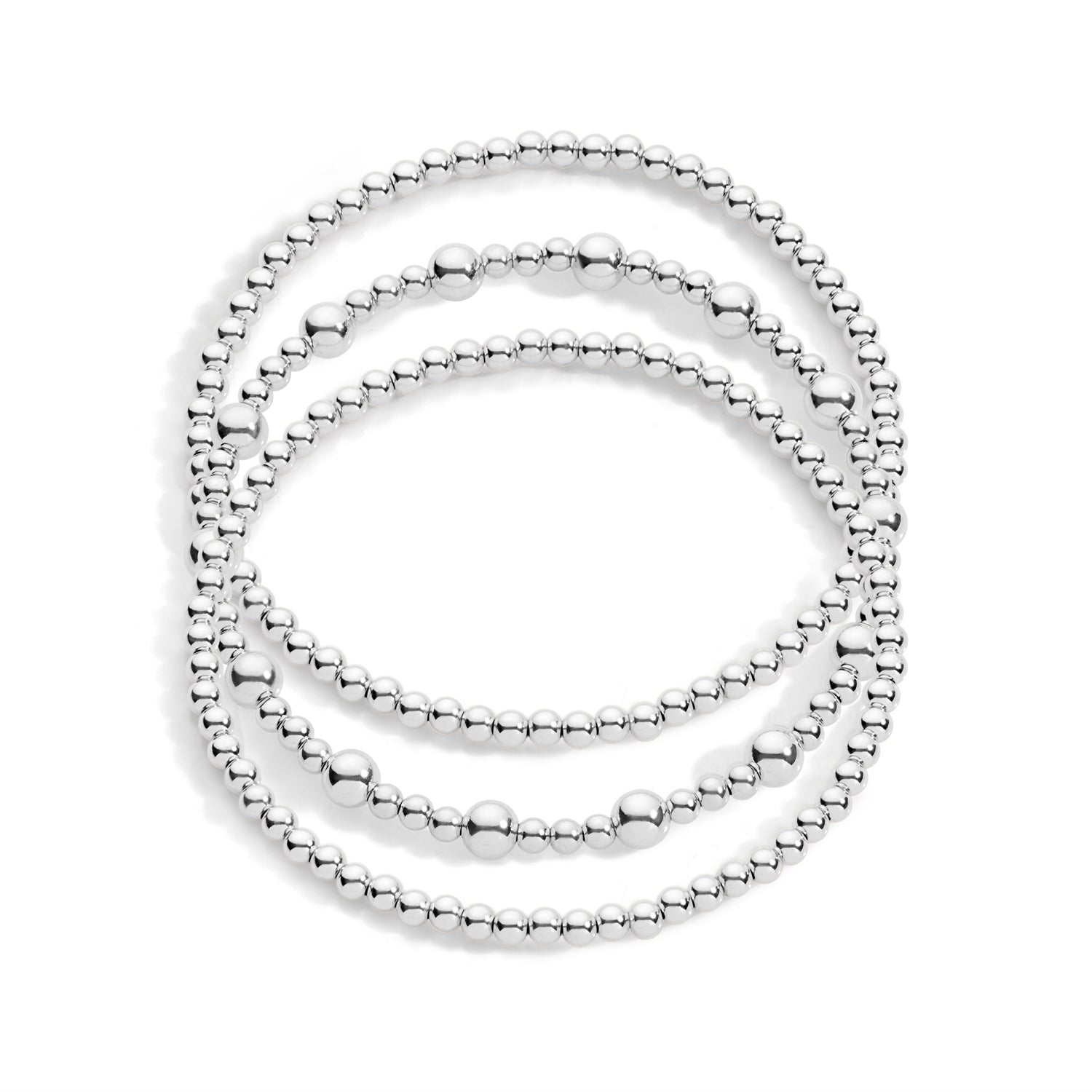 A stack of three bracelets, with varying sizes of beads in silver colors, on a white background.