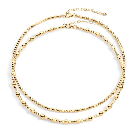 A gold-filled necklace stack featuring two interlinked chains with gold-filled beads.