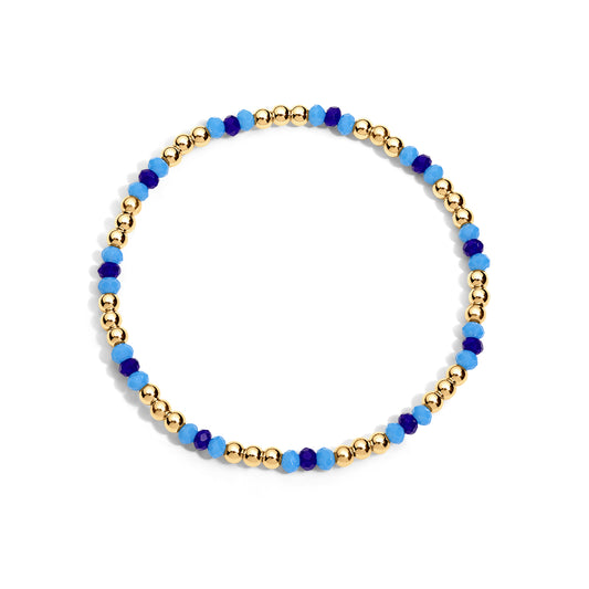 A gold-colored bracelet with blue beads, presented against a white background.