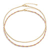 Two-layered gold-colored necklace with pink semi-precious gemstones and 14k gold-filled beads, displayed against a white background.
