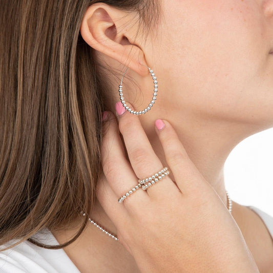 Model wearing sterling silver beaded hoop earring