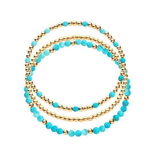 A stack of three bracelets, one featuring gold-filled beads and another with gold-filled beads and turquoise gemstones.