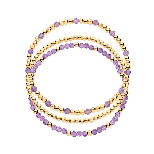 A stack of three bracelets, one featuring gold-filled beads and another with gold-filled beads and amethyst gemstones.