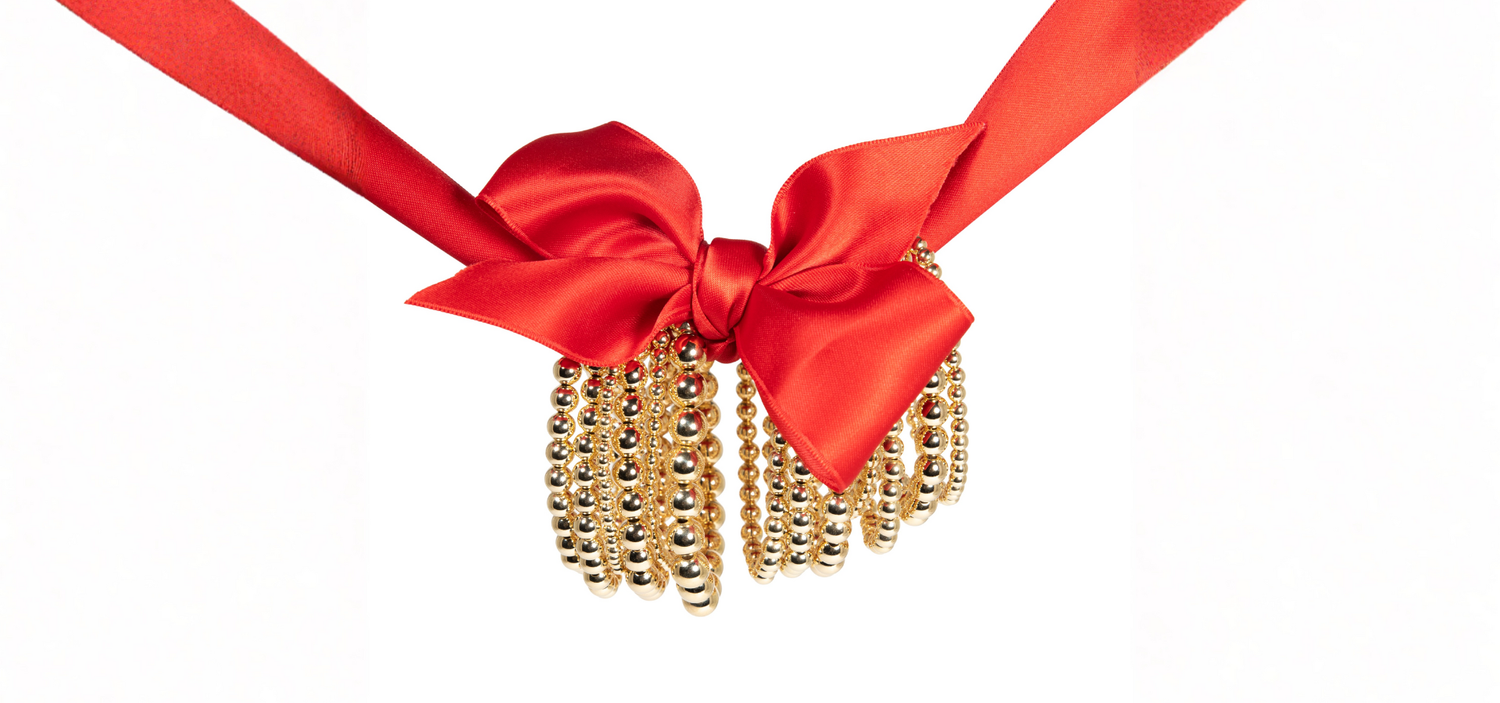 Red ribbon with a gold bead tassel on a white background