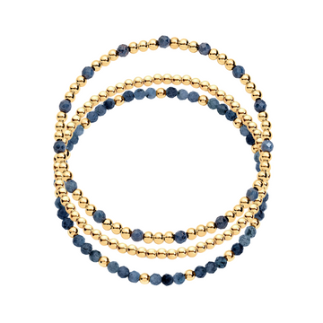 A stack of three bracelets, one featuring gold-filled beads and another with gold-filled beads and blue gemstones.