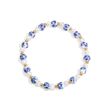 Bracelet with blue floral beads and gold accents on a white background