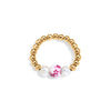 Gold beaded ring with a pink floral bead and a pearl on a white background