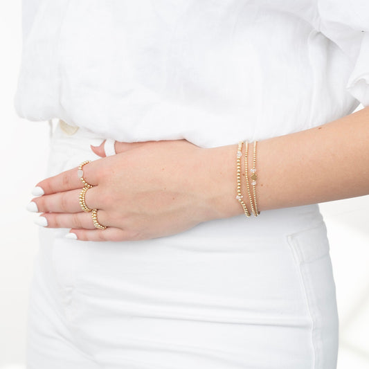 Model wearing gold filled beaded bracelets and rings with herkimer diamonds