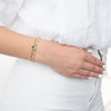 wrist with 3 gold filled and gemstones bracelets showing 2 rings