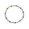 Bracelet with gold, blue, and white beads on a white background