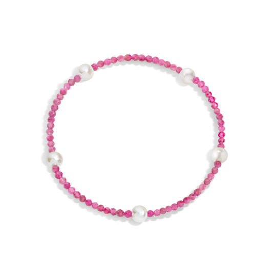 A bracelet with pink gemstones and white pearls, displayed on a white background.