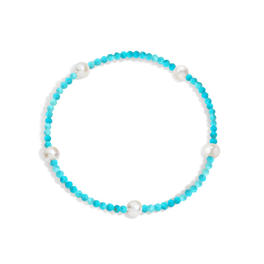 A bracelet with turquoise gemstones and white pearls, displayed on a white background.