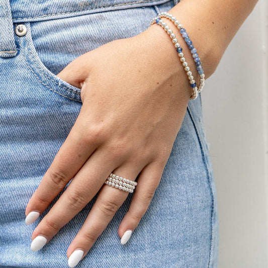 Model wearing sterling silver beaded bracelet with kyanite gemstones and sterling silver beaded rings