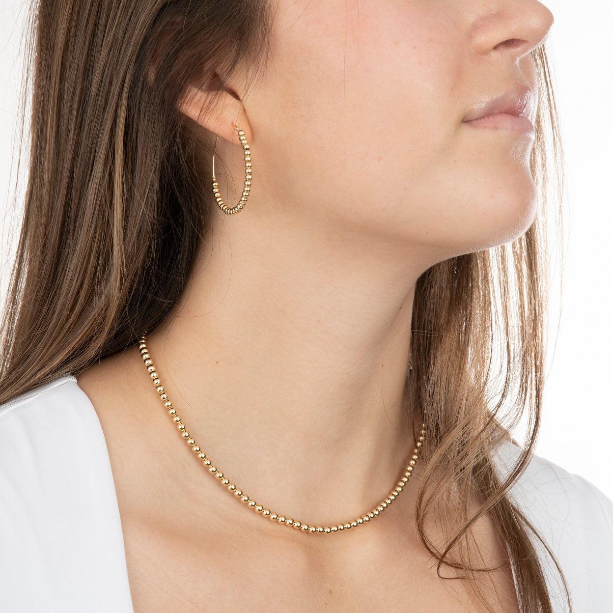 Model wearing gold filled hoop earrings and necklace